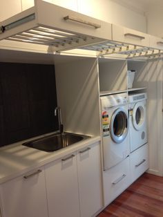 an overhead view of a washer and dryer in a small room with stairs