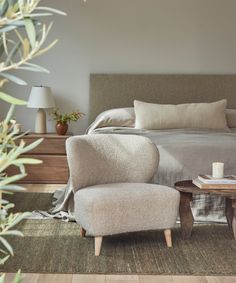 a bedroom with a bed, chair and nightstand