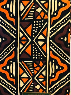 an orange, black and white design on a piece of cloth