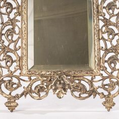 an ornate gold framed mirror on a white background