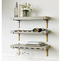 three shelves with wine glasses and bottles on them