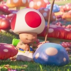 a little boy sitting on top of a mushroom next to other mushrooms in the grass