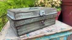 an old trunk sitting on top of a table next to a potted planter