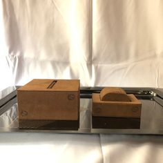 two wooden boxes sitting on top of a metal tray