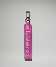 a pink keychain with the words millennium on it is hanging from a hook