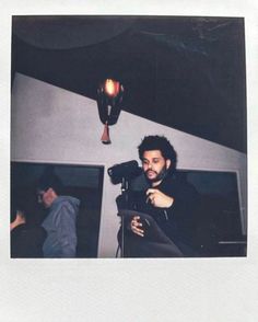 a polaroid photograph of a man holding a tablet