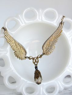 This necklace features two highly-detailed brass angel wings, and a central filigree bead drop. The bead is Czech glass--transparent white with metallic gold flecks. I have hand-patina-ed and distressed the wings with an antiqued white finish. The necklace secures with a lobster clasp. ------------------- **Please be sure to read my shipping and store policies, and don't hesitate to send me a message with any questions you may have! INTERNATIONAL BUYERS: Please be aware that there may be taxes or customs fees that are not included in the purchase price. I cannot reimburse for additional fees. Angel Wings Pendant, Angel Wings Jewelry, Wings Pendant, Glass Transparent, Angel Wing Pendant, Cardboard Gift Boxes, Gold Flecks, Glass Gifts, Fantasy Jewelry