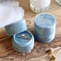 an open ring box sitting on top of a wooden table