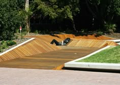 a man riding a skateboard up the side of a wooden ramp in a park