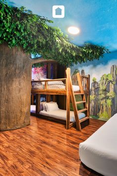 there is a bunk bed in the corner of this room with a tree on the wall