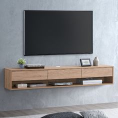 a flat screen tv mounted to the side of a wooden entertainment center in a living room