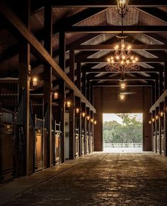 the inside of a horse barn with chandeliers