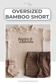 A flat-lay of a toddler outfit featuring a beige T-shirt with the text "Keeping it Authentic" in cursive, paired with brown drawstring shorts and matching beige socks, displayed on a light surface.