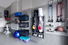 there are many different sports equipment in this room, including balls and gym equipment on the wall