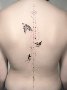 the back of a woman's body with birds and arrows on it, as well as an arrow