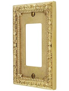 an ornate light switch plate cover in gold with a decorative design on the front and sides