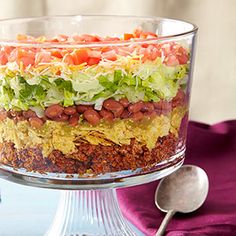 a layered salad with beans, lettuce and tomatoes