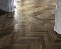 an open door in a room with wood flooring and parquet pattern on the floor