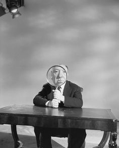 a man sitting at a table with a magnifying glass over his face