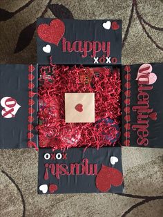 two valentine's day gifts made out of tissue paper and red shredded grass on the floor