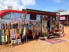 an old camper has been decorated with art and crafts for sale on the side