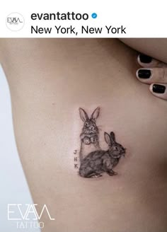 a woman's stomach with a tattoo of two rabbits on it