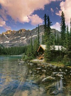 a cabin on the shore of a mountain lake