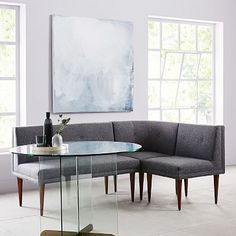 a living room with a glass table and gray couch