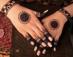 two hands with henna tattoos on them