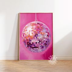 a pink poster with a disco ball hanging from it's side in an empty room