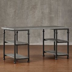 two metal tables sitting on top of a hard wood floor next to a gray wall