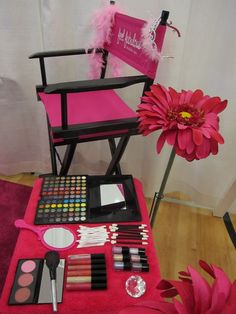 a pink chair sitting on top of a wooden floor next to a red table cloth