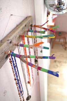 there are many different colored beads hanging on the wall