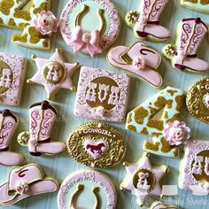 pink and gold decorated cookies are arranged on a table