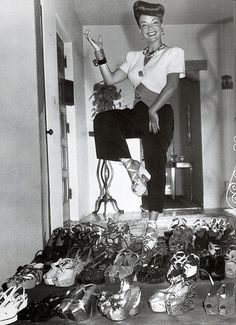 a woman standing on top of a pile of shoes