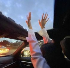 two people in a car with their hands up