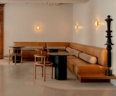 an empty restaurant with tables and benches in it's center area, surrounded by brick pillars