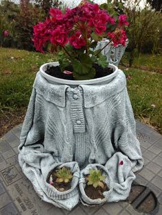 a potted plant sitting on top of a cement slab with flowers in the middle