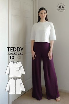 a woman standing in front of a door wearing wide legged pants and a white top