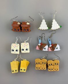 six different lego style earrings are shown on a gray surface, one is yellow and the other is brown