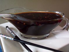 a glass pitcher filled with liquid next to two black straws on a white plate