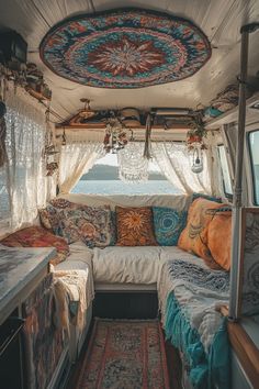 the inside of a camper with lots of pillows and rugs on the floor