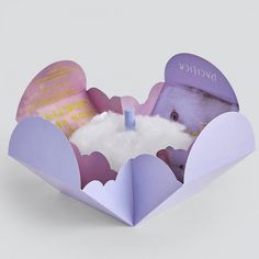 an open heart shaped box with a candle inside