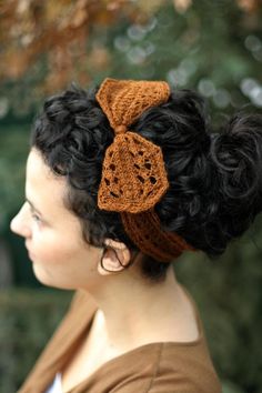 a woman with black hair wearing a brown crochet headband and a bow