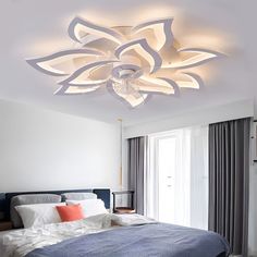 a bed room with a neatly made bed and a ceiling light that is lit up