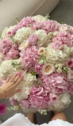 a woman holding a bouquet of pink and white flowers