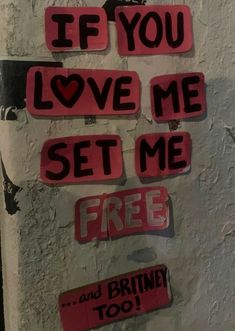 some red and black stickers on a white wall with the words if you love me set me free