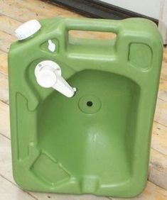 a green plastic container sitting on top of a wooden floor