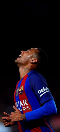 a soccer player with his eyes closed looking up at the sky and holding his hands together