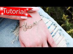 a woman's hand with the word love written on it and a red ribbon around her wrist